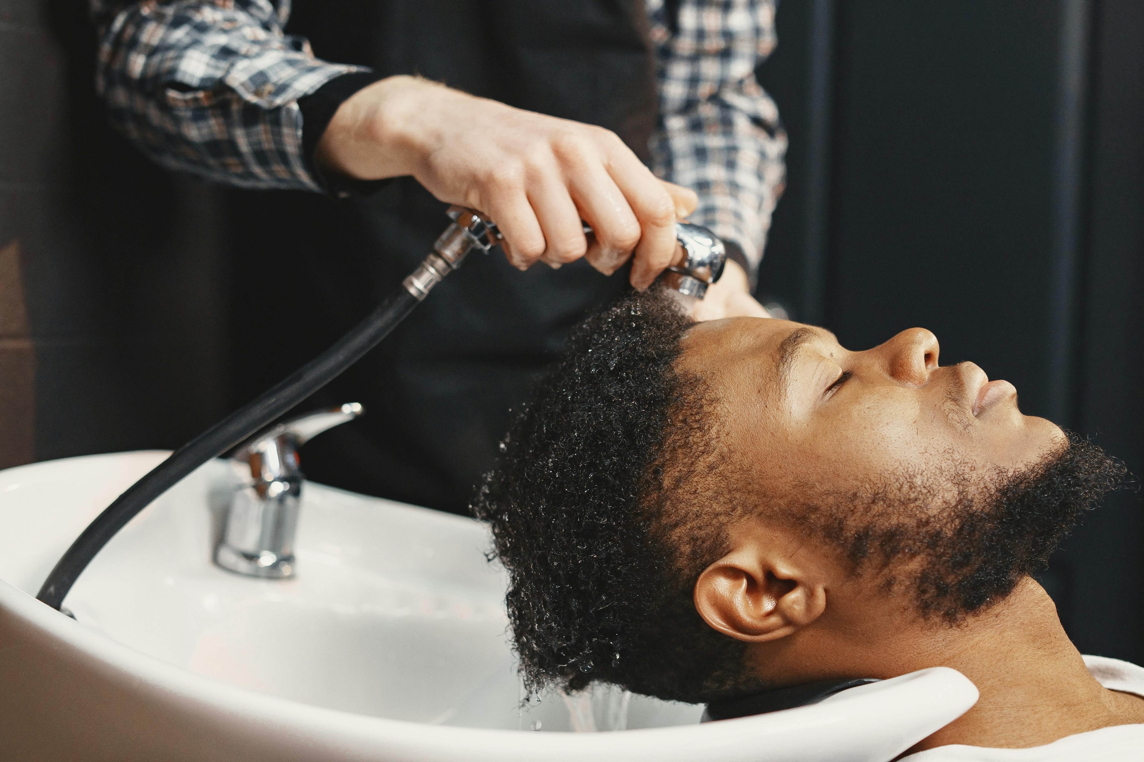 A man washing his hair, a natural and important grooming tips for a better hair care routine.