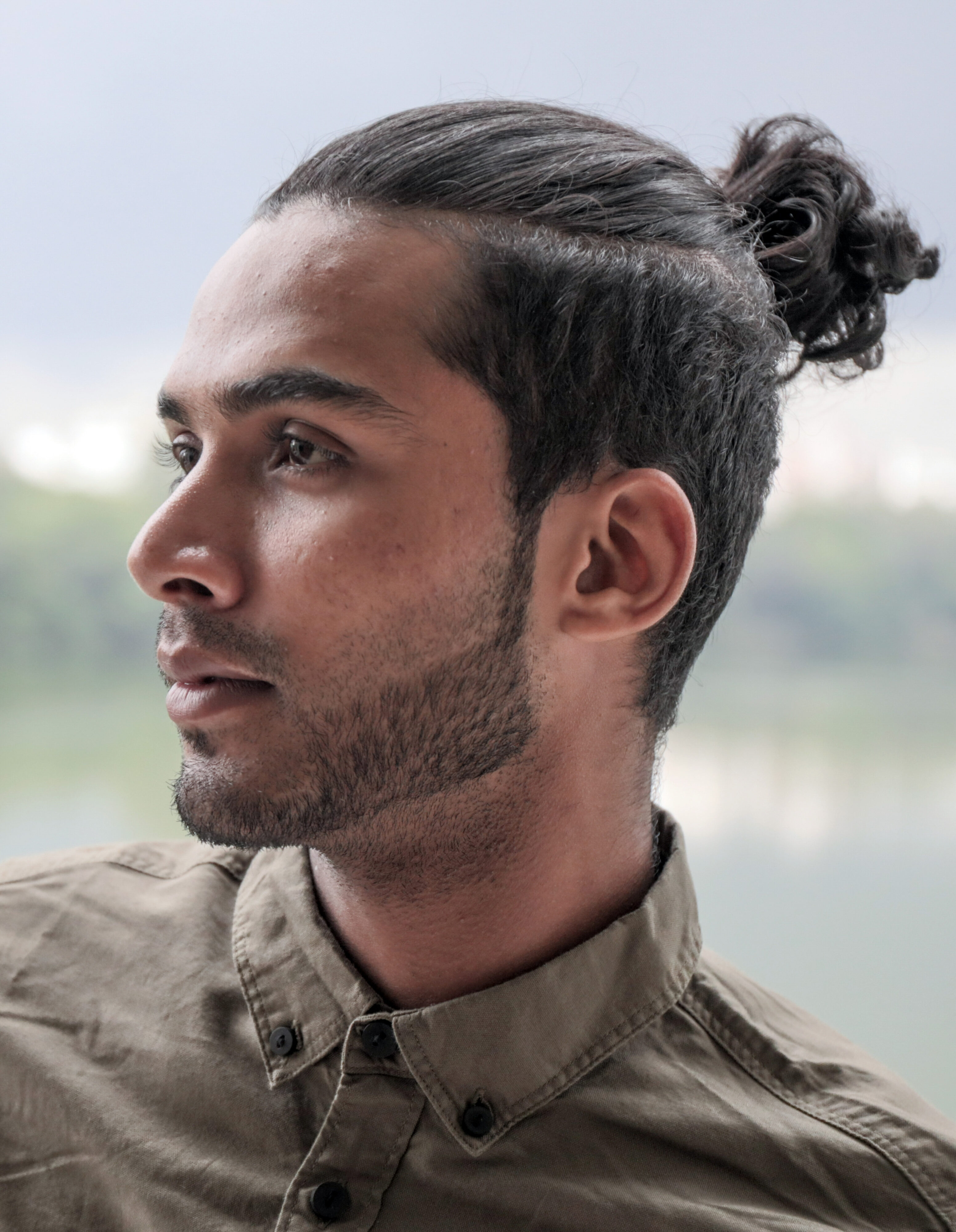 Image of Curly top knot haircut for oval face male