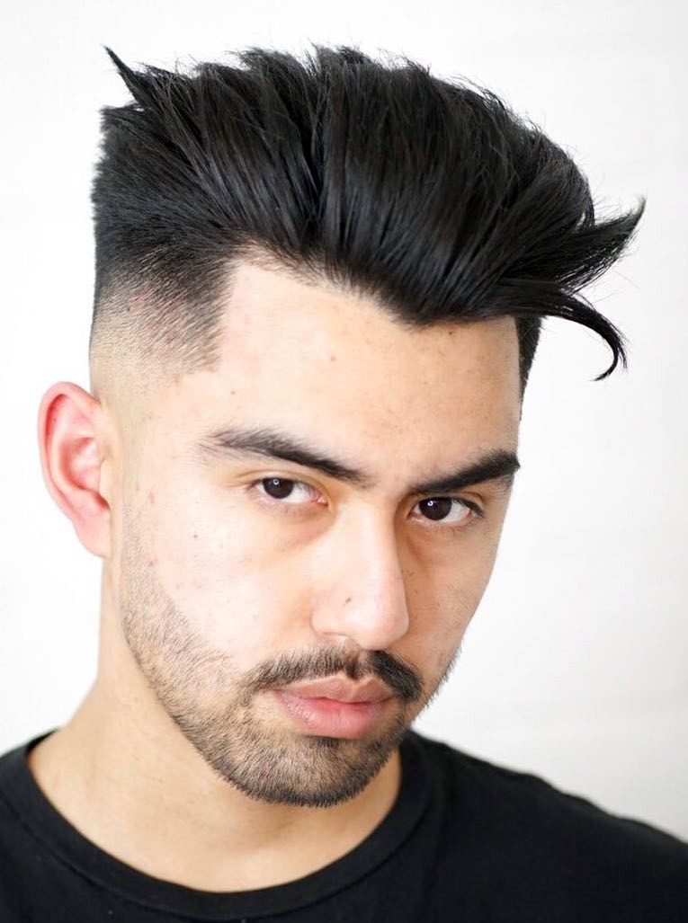 dense hair in slicked-back high-volume pompadour. widow peak